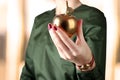 Businesswoman standing and holding golden apple in her hand. Royalty Free Stock Photo