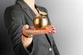 Businesswoman standing and holding golden apple in her hand. Royalty Free Stock Photo
