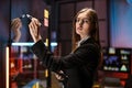 Businesswoman standing near glass office wall, using tablet computer