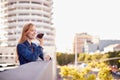 Businesswoman Standing Outside Office Building Using Mobile Phone With City Skyline In Background Royalty Free Stock Photo