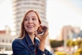 Businesswoman Standing Outside Office Building Using Mobile Phone With City Skyline In Background Royalty Free Stock Photo