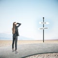 Businesswoman standing on road and looking on luck and failure sign post Royalty Free Stock Photo