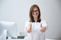 Businesswoman standing with thumbs up in office Royalty Free Stock Photo