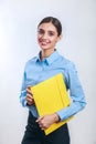 Businesswoman standing with yellow folder on gray background Royalty Free Stock Photo