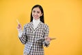 A businesswoman stands against an isolated yellow background with her tablet in her hand Royalty Free Stock Photo