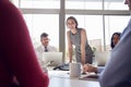 Businesswoman stands listening to colleagues at a meeting Royalty Free Stock Photo