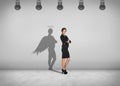 Businesswoman stands with shadow on the wall