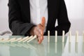 Businesswoman Stopping Dominoes From Falling Royalty Free Stock Photo