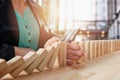 Businesswoman stops a chain fall like domino game. Concept of preventing crisis and failure in business. Royalty Free Stock Photo