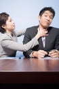 Businesswoman strangling businessman