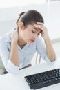 Businesswoman suffering from headache in front of laptop Royalty Free Stock Photo