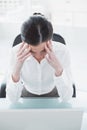 Businesswoman suffering from headache in front of laptop Royalty Free Stock Photo