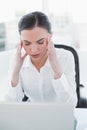 Businesswoman suffering from headache in front of laptop Royalty Free Stock Photo