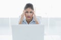 Businesswoman suffering from headache with laptop at office Royalty Free Stock Photo