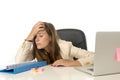 Businesswoman suffering stress at office computer desk looking worried depressed and overwhelmed