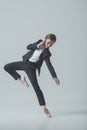 businesswoman in suit and ballet shoes dancing and talking on smartphone