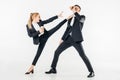 businesswoman in suit kicking businessman with coffee to go Royalty Free Stock Photo