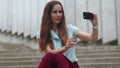 Businesswoman taking selfie photo on smartphone. Woman pouting lips outdoors Royalty Free Stock Photo