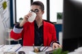 Businesswoman taking a sip of coffe working in corporate office