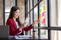 businesswoman talking on cellphone, writing notes on colorful papers in office, employee checking financial documents Royalty Free Stock Photo