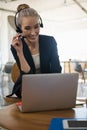 Businesswoman talking through headset while using laptop Royalty Free Stock Photo