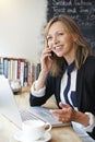 Businesswoman Talking On Mobile Phone In Cafe Royalty Free Stock Photo