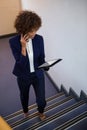 Businesswoman talking on mobile phone while using digital tablet Royalty Free Stock Photo