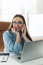 Businesswoman talking on mobile phone while writing sticky notes Royalty Free Stock Photo