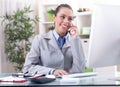 Businesswoman talking on the phone in office and working on comp Royalty Free Stock Photo