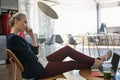 Businesswoman talking on smart phone while relaxing on chair at office Royalty Free Stock Photo