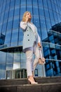 Young confident woman stands near business center and talks by smartphone. Royalty Free Stock Photo