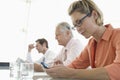 Businesswoman Text Messaging On Cell Phone At Conference Table Royalty Free Stock Photo