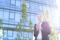 Businesswoman text messaging through cell phone on sunny day Royalty Free Stock Photo