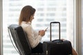 Businesswoman texting on smartphone while waiting in airport lou Royalty Free Stock Photo