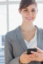 Businesswoman texting and smiling at camera Royalty Free Stock Photo