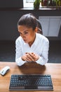 Thoughtful businesswoman thinks sitting at her workplace folded palms. Young serious woman looking at side. High quality Royalty Free Stock Photo