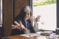 Businesswoman tired feels sitting at office desk with laptop and crumpled paper. woman can not concentrate and fail having work. Royalty Free Stock Photo