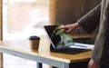 A businesswoman touching and pointing finger at digital tablet screen as a computer pc with coffee cup and Royalty Free Stock Photo