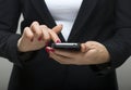 Businesswoman touching smartphone in her hands