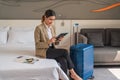 Businesswoman traveller sitting on bed using computer tablet in hotel room Royalty Free Stock Photo