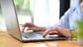 Businesswoman typing on laptop keyboard, using laptop computer, working on her tasks Royalty Free Stock Photo