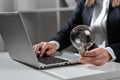 Businesswoman Typing Recent Updates On Lap Top On Desk Holding Lightbulb. Woman In Office Writing Important Message On