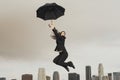 Businesswoman With An Umbrella Flying Above City