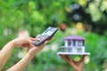 Businesswoman using a calculator and wooden house on green background, Accountants calculating profit and Interest rates concept