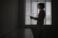 Businesswoman Using Cellphone In Dark Office