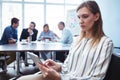 Businesswoman using digital tablet against colleagues in meeting room Royalty Free Stock Photo