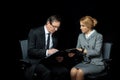 Businesswoman using digital tablet and looking at businessman signing papers Royalty Free Stock Photo