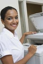 Businesswoman Using Fax Machine In Office