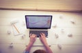 Businesswoman using her laptop at desk with paper balls Royalty Free Stock Photo