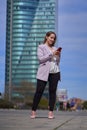 Businesswoman using her mobile phone outdoors in the financial district. Royalty Free Stock Photo